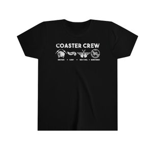 Op de afbeelding: Zwart T-shirt met de tekst "COASTER CREW" en vier afbeeldingen met een achtbaan-thema. Daaronder staan de namen "Mine Train", "Slinky", "Rock 'n' Roll" en "Barnstormer".