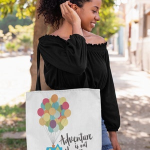 May include: A white tote bag with a house and colorful balloons, the text "Adventure is out there" is printed on the bag.