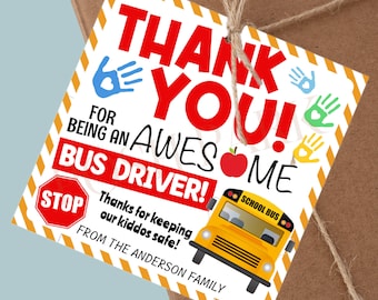 Puede incluir: Una etiqueta de agradecimiento blanca con rayas amarillas y rojas. La etiqueta dice "¡Gracias! Por ser un conductor de autobús increíble!" con una señal de stop roja, un autobús escolar amarillo y huellas de manos rojas. El texto "¡Gracias por mantener a nuestros niños seguros! De la familia Anderson" también está en la etiqueta.