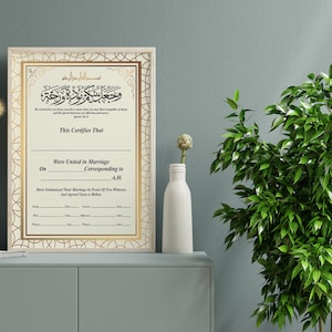 May include: A framed Islamic marriage certificate with gold accents. The certificate has Arabic text and the words "This Certifies That" and "Were United in Marriage".