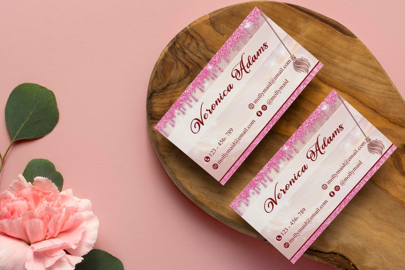 May include: Two pink and white business cards with a pink glitter design. The cards feature the name "Veronica Adams" and a phone number, email address, and social media icons.