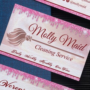 May include: Pink and white business card with a gold glitter design. The card says "Molly Maid Cleaning Service" and "Daily - Weekly - Monthly - One Time".