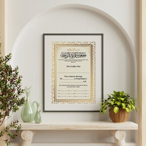 May include: A gold framed certificate with an ornate border and Arabic calligraphy. The text reads "This Certifies That... Were United in Marriage... Corresponding to... A.M."