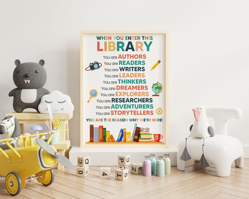 May include: A colorful poster with the text "WHEN YOU ENTER THIS LIBRARY" and a list of words describing the roles of people who use libraries, such as "AUTHORS", "READERS", "WRITERS", "LEADERS", "THINKERS", "DREAMERS", "EXPLORERS", "RESEARCHERS", "ADVENTURERS", and "STORYTELLERS". The poster also includes the text "YOU ARE THE REASON WHY WE'RE HERE!"