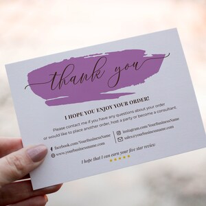 K&ouml;nnte beinhalten: Eine Dankeskarte mit einem violetten Pinselstrich-Design. Die Karte enth&auml;lt den Text "Vielen Dank" und "Ich hoffe, Sie genie&szlig;en Ihre Bestellung!" mit den Kontaktdaten des Unternehmens.