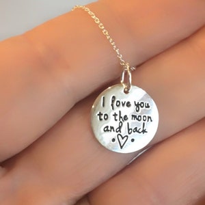 May include: Silver necklace with a round pendant that says "I love you to the moon and back" with a heart symbol.