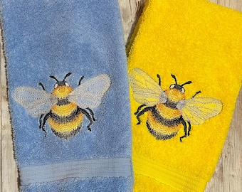 Toallas de mano de baño de rizo de algodón turco bordadas con diseño de abejorro y alas plateadas brillantes, disponibles en 17 colores a elegir.