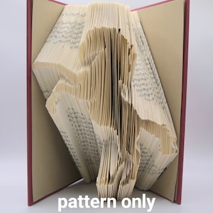 May include: A book with pages folded into the shape of a horse. The book has a red cover and the pages are a cream color. The text "pattern only" is printed below the book.