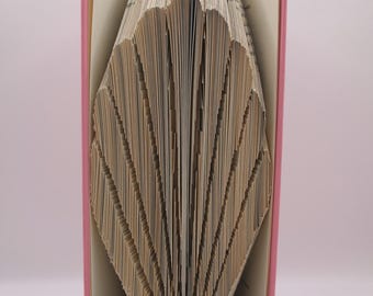 Puede incluir: Un libro rosa con páginas plegadas en un diseño de concha. La portada del libro es rosa y las páginas son beige. El texto "pattern only" es visible en la parte inferior. Es un artículo decorativo.