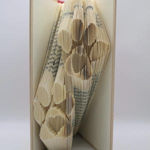May include: A book with pages folded to create a paw print design. The book is open, revealing the intricate folded pattern. The text "pattern only" is visible at the bottom of the image.