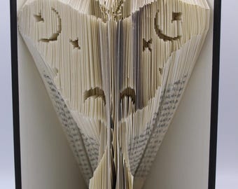 Puede incluir: Un patrón de arte de libro para una artesanía de papel 3D de una polilla. El patrón se pliega en un libro para crear una escultura 3D.