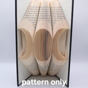 May include: A book art pattern for a triple moon design. The pattern is folded into a three-dimensional shape, with the pages forming the shape of the moon.