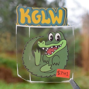 Le roi gésier et le sorcier lézard Gizzy Gator emballé KGLW Sticker transparent 2,5"