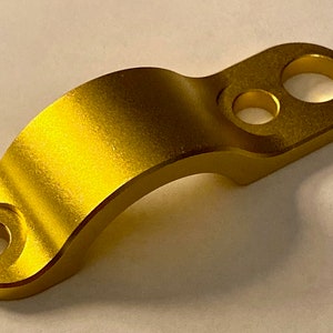 以下が含まれることがあります： 両端に2つの穴のある金色の金属製クランプ。クランプは湾曲しており、滑らかでブラッシュ仕上げになっています。