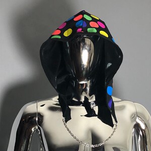 May include: A black hooded garment with a colorful polka dot pattern. The hood is pulled up and the garment is worn on a silver mannequin.