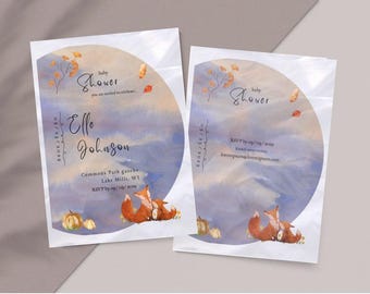 May include: Baby shower invitations with watercolor design. The invitations feature a circular design with a blue and orange watercolor background, autumn leaves, and two foxes. The text includes the names Elle Johnson, date, and location.