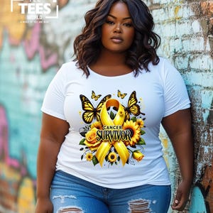 K&ouml;nnte beinhalten: Wei&szlig;es T-Shirt mit einem gelben Band, Schmetterlingen und Sonnenblumen. Das Band tr&auml;gt den Schriftzug "Cancer Survivor".