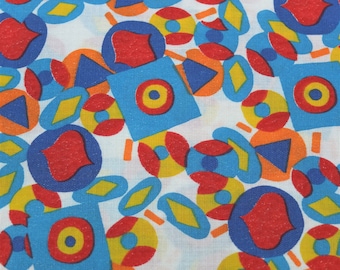 Può includere: Un tessuto bianco con un motivo ripetitivo di forme geometriche blu, rosse e gialle. Le forme includono cerchi, quadrati, rombi e triangoli.