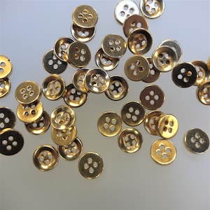 15 gold-coloured round buttons with a diameter of 1 cm. The second variant contains 100 pieces of this button and costs 20,-