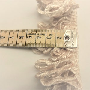 May include: A close-up of a beige velvet trim with a measuring tape showing it is 3 cm wide. The tape reads "hochstmass" and "Made in Germany".