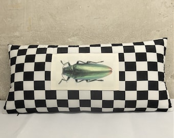 Almohada de cuadros blancos y negros con escarabajo