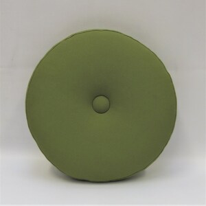 May include: A round, green cushion with a button in the center.
