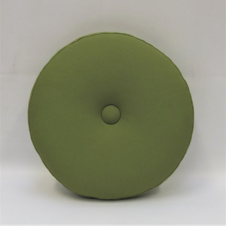 May include: A round, green cushion with a button in the center.