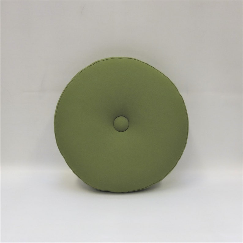 May include: A round, green cushion with a button in the center.