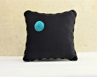 pequeño cojín de terciopelo con turquesa, cogollo cosido y keder a rayas