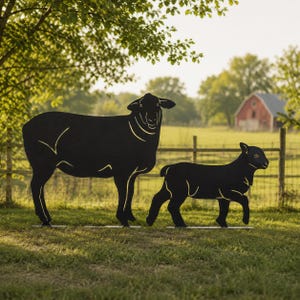 May include: Black metal silhouette of a sheep and a lamb standing on a grassy lawn. The sheep is larger, with detailed lines. The lamb is smaller, walking beside the sheep. A red barn and fence are in the background.