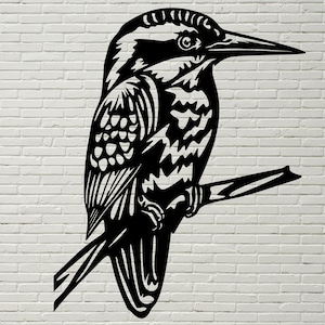 May include: Black and white silhouette of a kingfisher bird perched on a branch. The bird is facing right and has a long beak. The image is a cut-out design, ideal for wall decor.