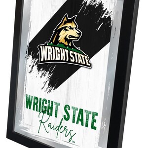 May include: Framed print with a black and white background featuring a green and gold wolf mascot with the text "Wright State" and "Wright State Raiders" in green text.