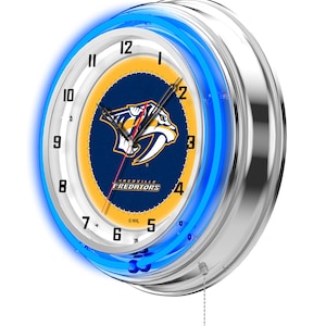 May include: A round, chrome-finished neon clock with a blue neon ring. The clock face features the Nashville Predators logo in navy blue and gold, with the team name below. The clock has a pull chain.