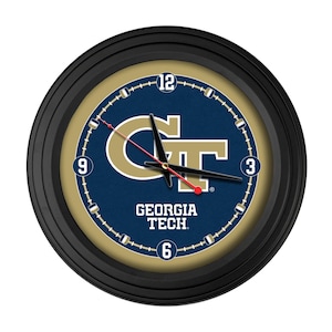 May include: Round black wall clock with a navy blue face featuring the Georgia Tech logo in gold. The clock has black hands and a red second hand. The numbers 3, 6, 9, and 12 are visible.