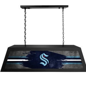 May include: Black pool table light with a Seattle Kraken logo on the shade. The logo is a blue and white 'S' with a red outline on a blue and gray background.
