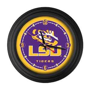 May include: Round black wall clock with a purple and gold face. The clock face features the LSU Tigers logo, the word "LSU" in gold block letters, and the word "TIGERS" in white. The clock hands are black and red.