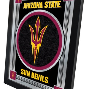 May include: Framed mirror featuring the Arizona State Sun Devils logo. The mirror has a black frame and a silver border. The logo is a maroon and gold trident on a black background, with "ARIZONA STATE" and "SUN DEVILS" in gold.