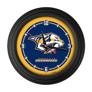 May include: Round black wall clock featuring the Nashville Predators logo. The clock face is navy blue with a yellow border and white numerals. The clock hands are black with a red second hand. The team name "Predators" is displayed at the bottom.