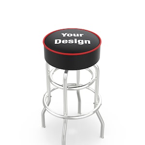 May include: A black bar stool with a chrome frame and a black padded seat with a red trim. The seat has the text "Your Design" printed in white.