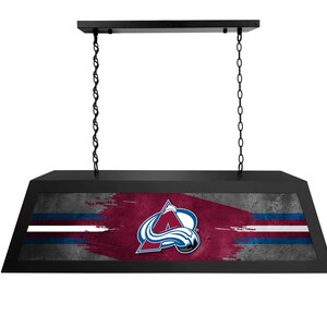 May include: Black hanging light fixture with a Colorado Avalanche logo on a distressed, red, white, and blue background.