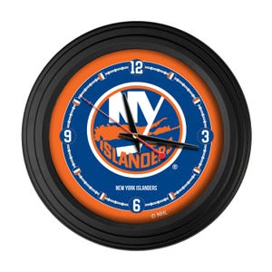 May include: Round black wall clock featuring the New York Islanders logo in blue and orange. The clock face has a blue outer ring with white numerals and a black hour and minute hand. The text "New York Islanders" is printed at the bottom.