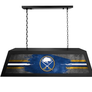 May include: Black hanging light fixture with a Buffalo Sabres team logo on a distressed blue and gold background.