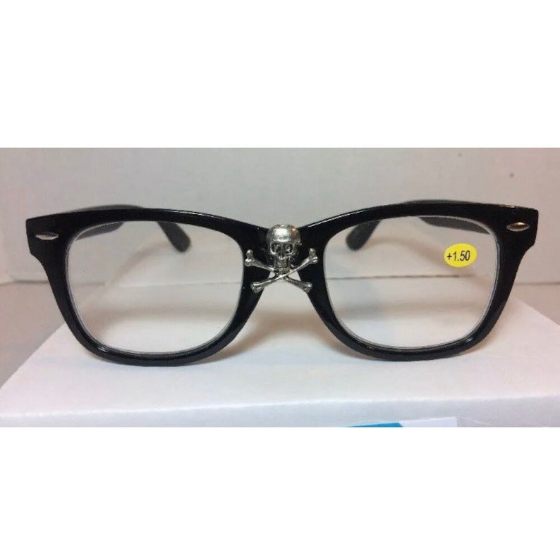 May include: Black plastic framed glasses with a skull and crossbones design on the bridge. The glasses have clear lenses and a +1.50 magnification.