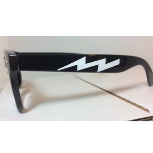 May include: Black sunglasses with a white lightning bolt design on the frame.