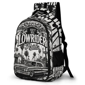 Könnte beinhalten: Ein schwarz-weißer Rucksack mit einem Grafikdruck eines Oldtimers auf einer Straße mit Palmen. Der Text "KEEP IT REAL" und "LOWRIDER PRIDE" ist in einer stilisierten Schriftart zu sehen. Der Rucksack verfügt über einen Tragegriff und Riemen.