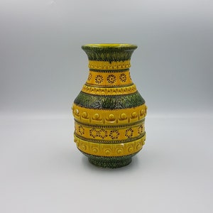 May include: A yellow and green ceramic vase with a geometric pattern. The vase has a wide mouth and a narrow base.