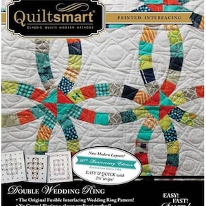 May include: A quilt pattern book titled "Quiltsmart Double Wedding Ring." The cover features a colourful quilt design with interlocking rings and squares in shades of blue, orange, green, and grey. The book includes the text "Easy & Quick with 6.35 cm strips!"