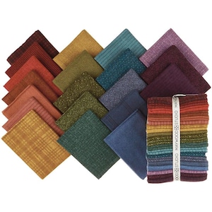 Op de afbeelding: Een verzameling diverse stoffen vierkanten in verschillende kleuren, waaronder tinten rood, oranje, geel, groen, blauw en paars. De stoffen hebben verschillende texturen en patronen, zoals visgraat, strepen en geometrische ontwerpen. Een bundel stoffen vierkanten is vastgebonden met een wit lint.