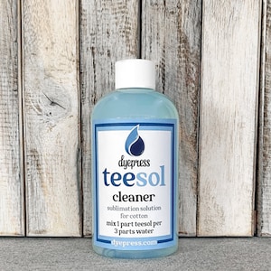May include: A blue bottle of dye press teesol cleaner for sublimation on cotton. The bottle has a white label with the text "dyepress teesol cleaner sublimation solution for cotton mix 1 part teesol per 3 parts water dyepress.com".