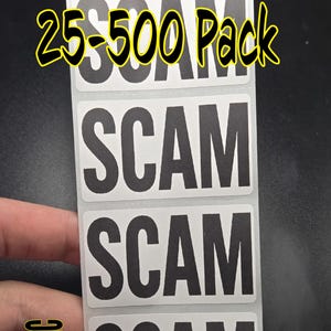 Puede incluir: Una tira de pegatinas rectangulares blancas con la palabra "SCAM" impresa en letras negras en negrita. El texto "25-500 Pack" está en la parte superior. Las pegatinas están sujetas por una mano. El logotipo "SlickSticksLLC" está en el lateral.